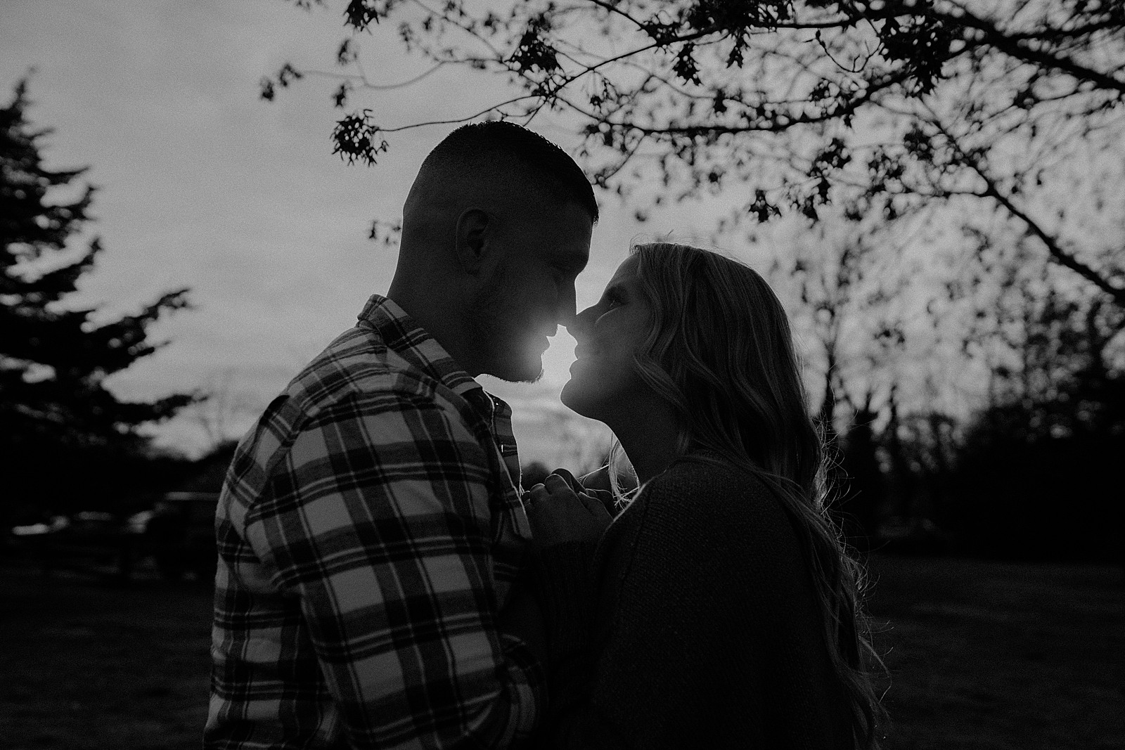 B&W Couple about to kiss out in the forest with sun shining through