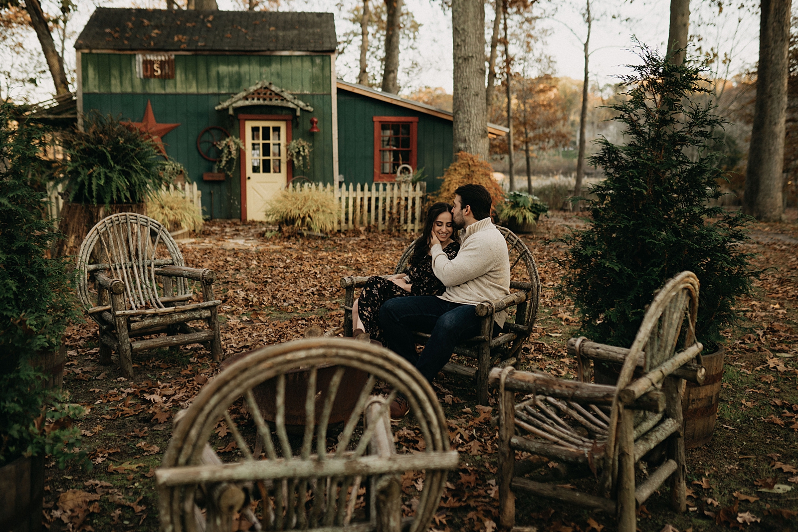 Couple sitting on wooden outdoor chairs in fall area
