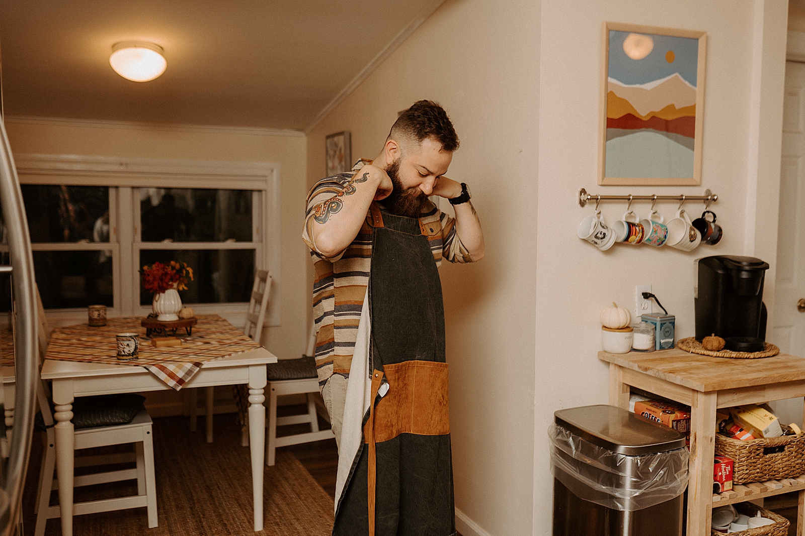 Man putting on apron while entering kitchen
