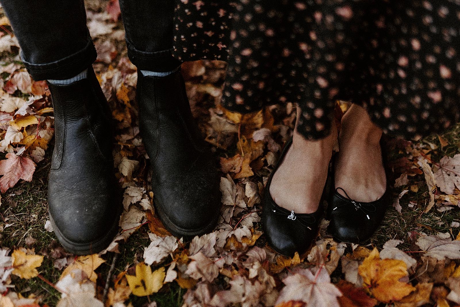 Closeup of couple's shoes on fall leaf ground