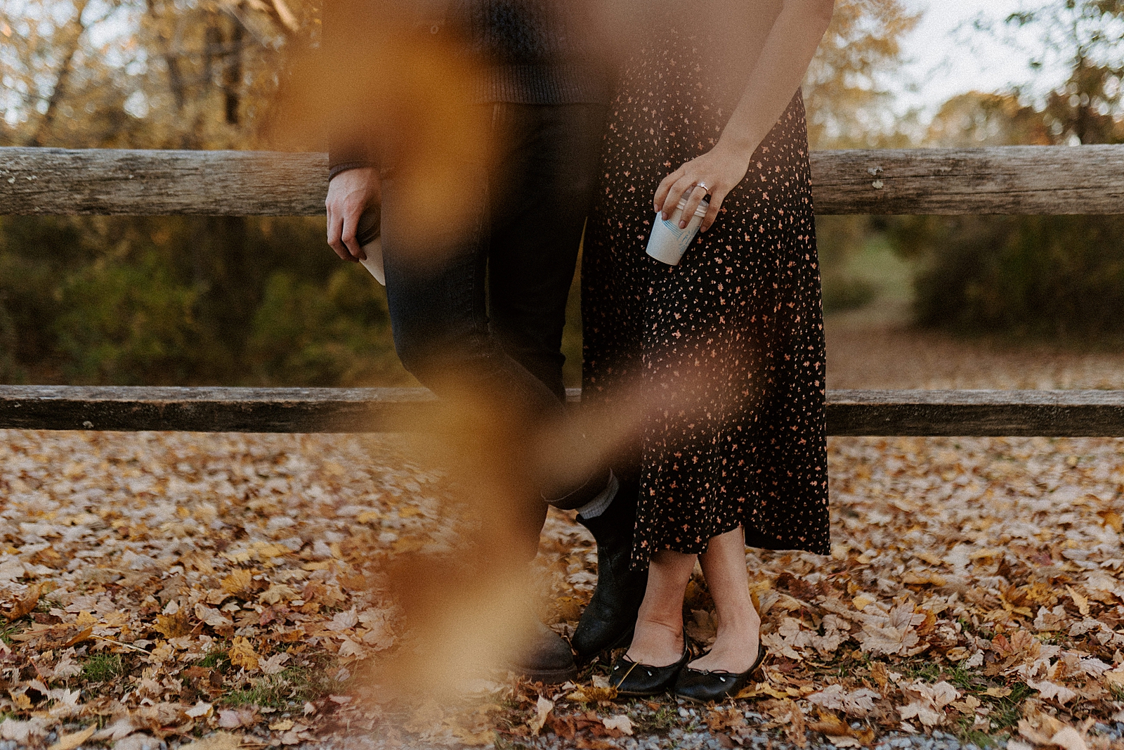 Portrait of lower half of couple standing on fall ground with leafs