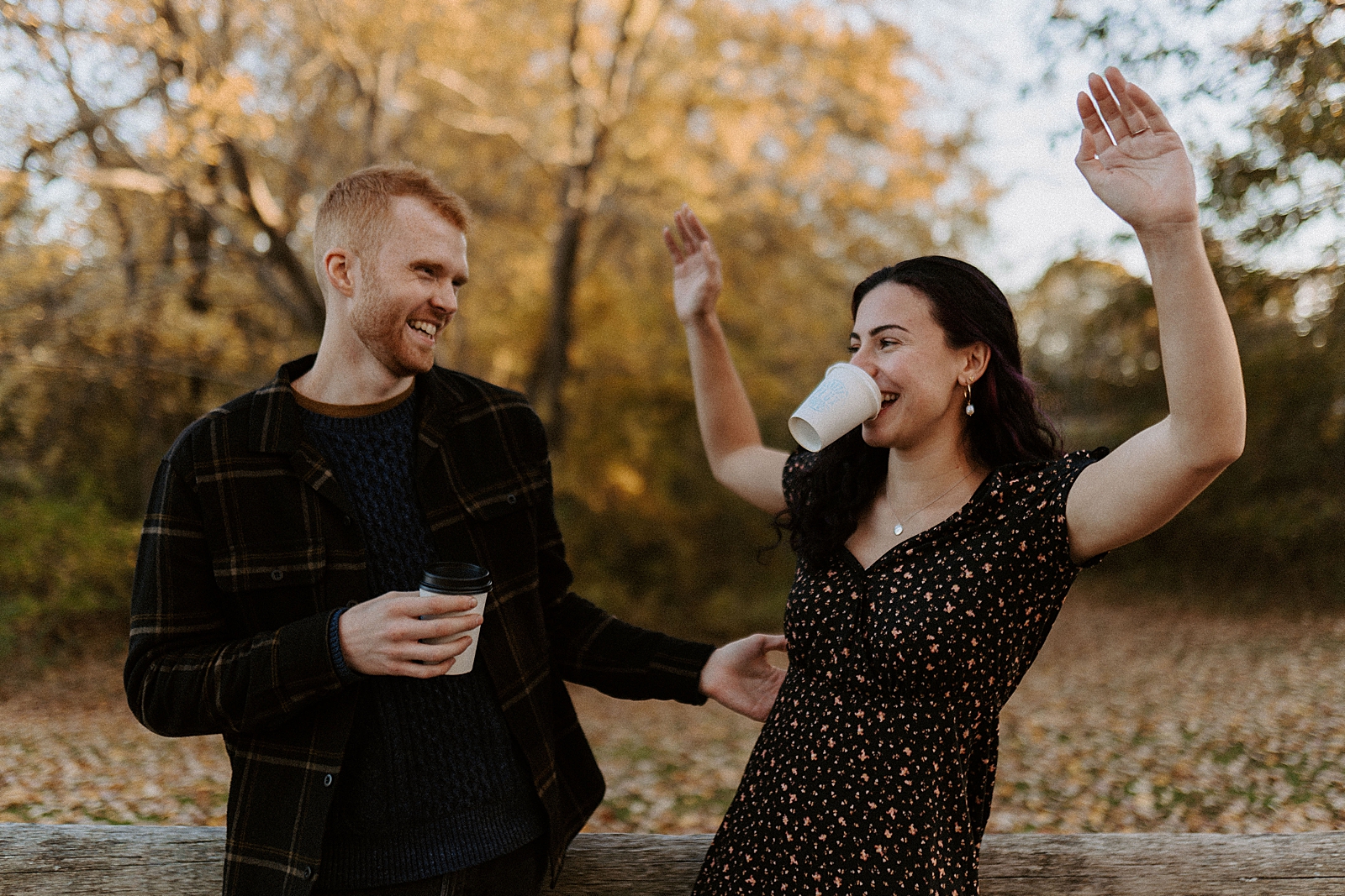 Couple in goofy poses with woman holding coffee cup by mouth outside