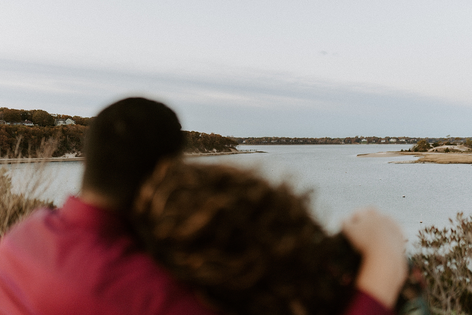 Couple holding each other and looking out to the water