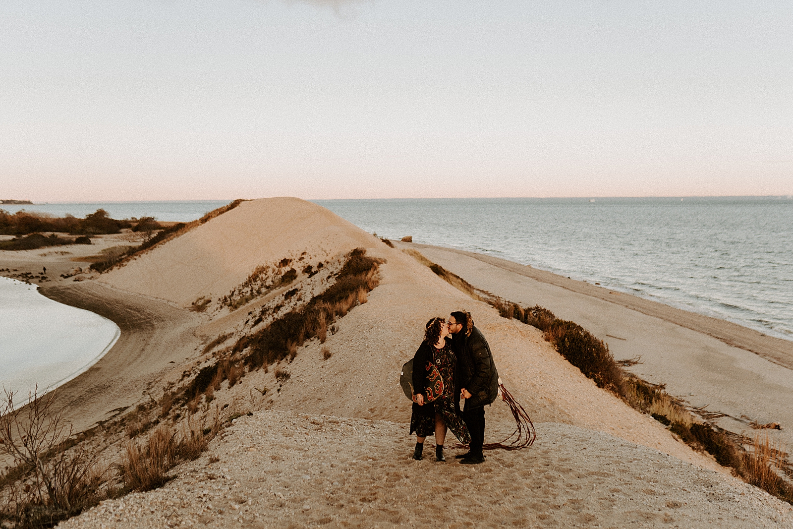 Couple kissing on sand hill