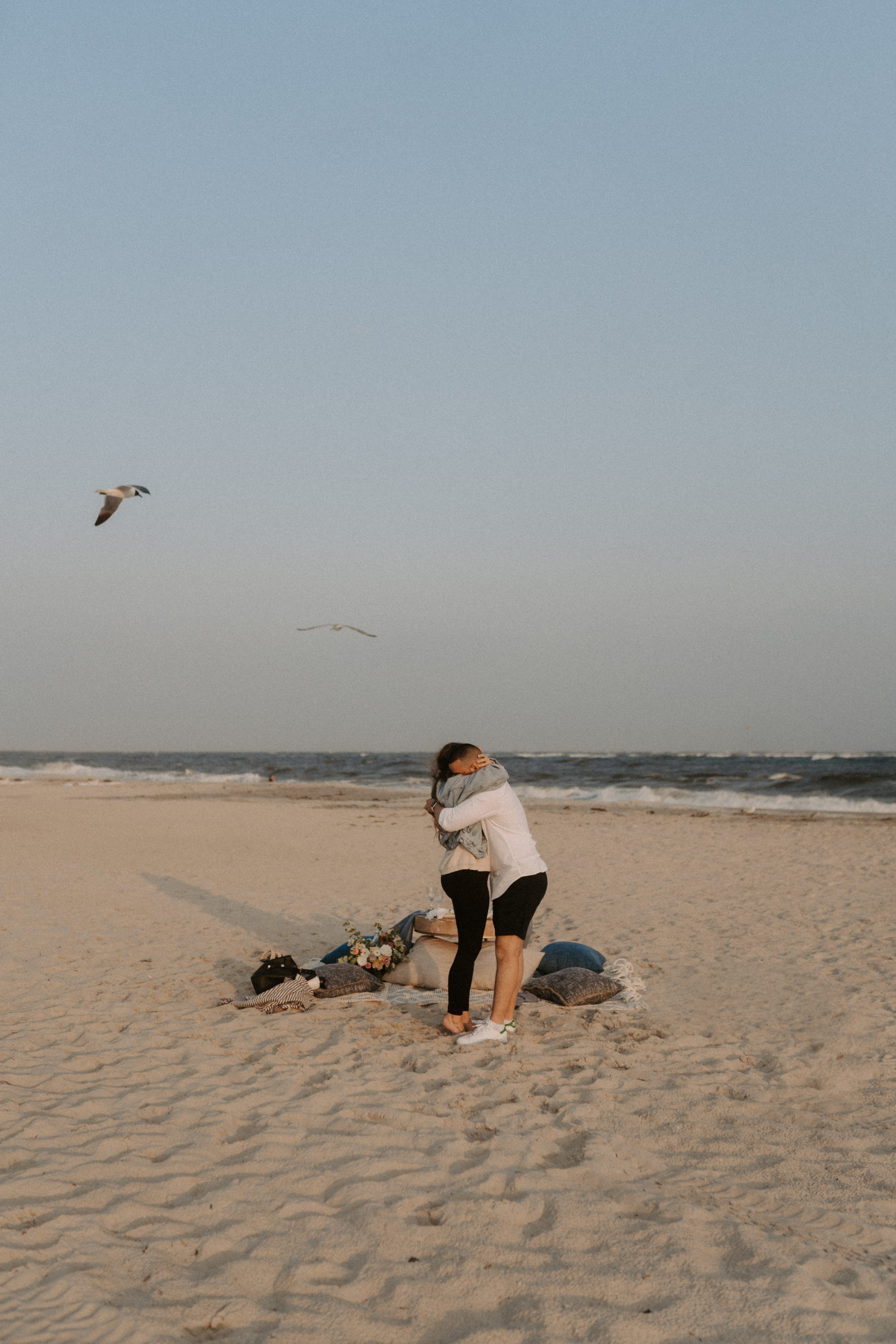 Man proposing to woman and hugging on the beach