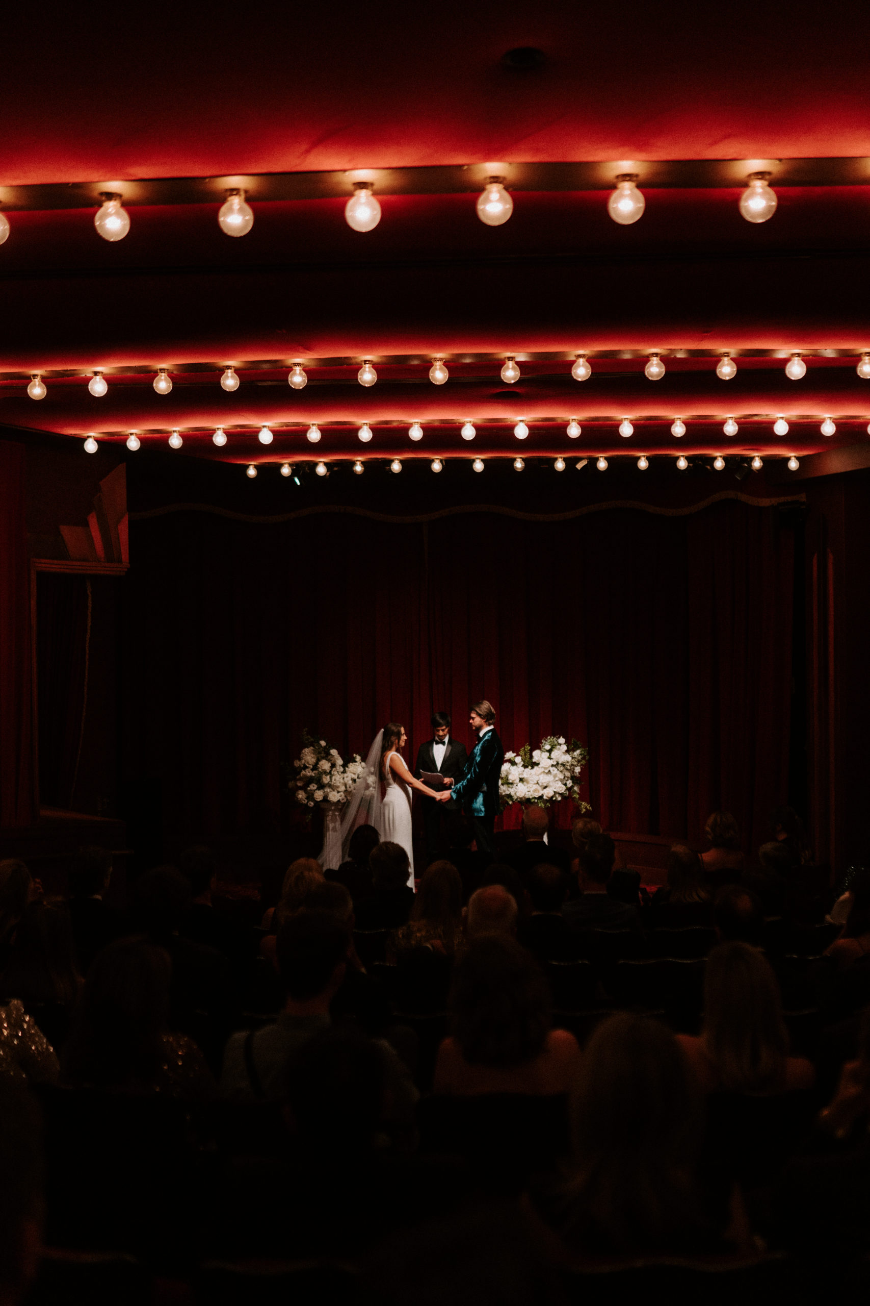 bride and groom holding hands in nyc cinema