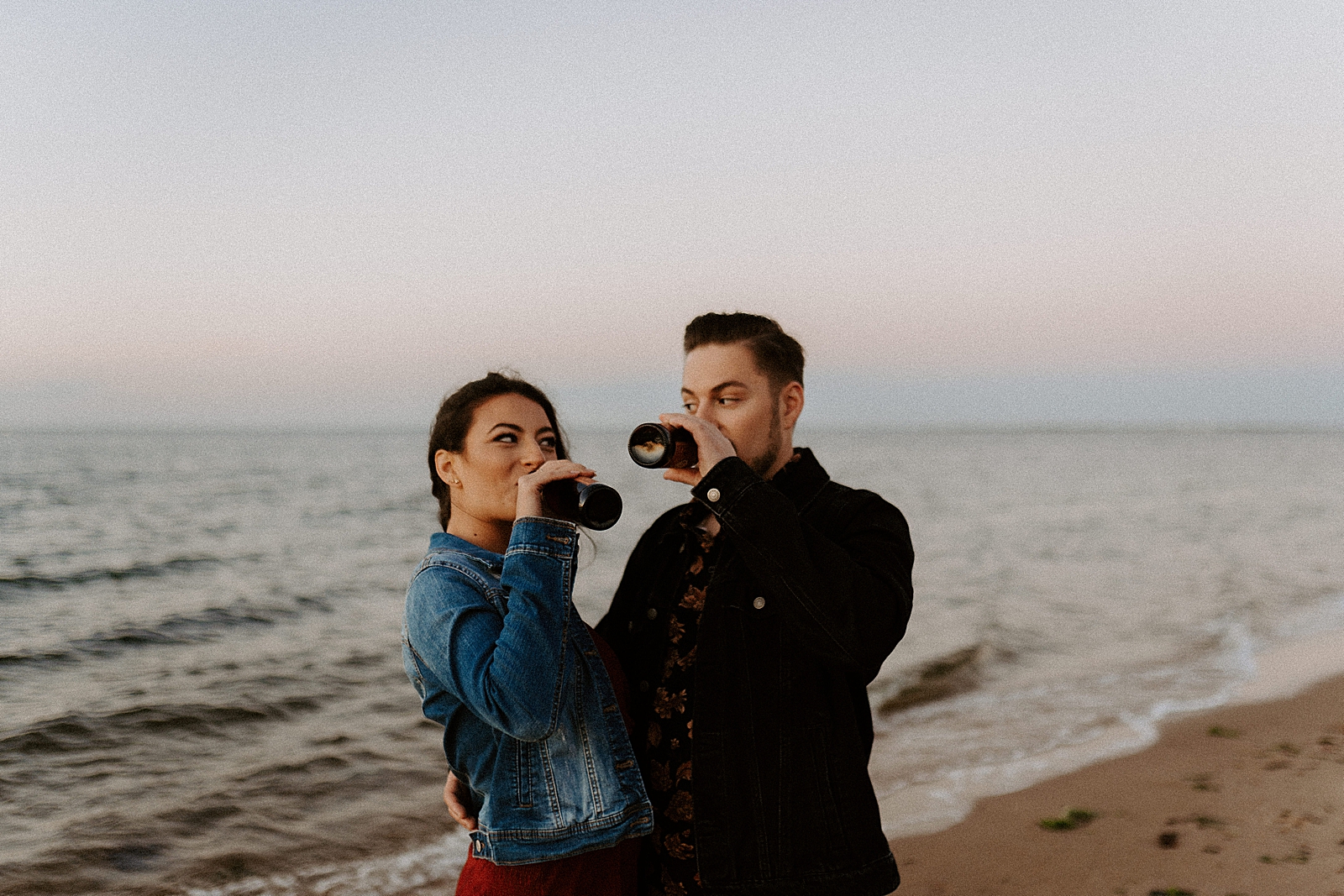 Couple drinking beer by the ocean