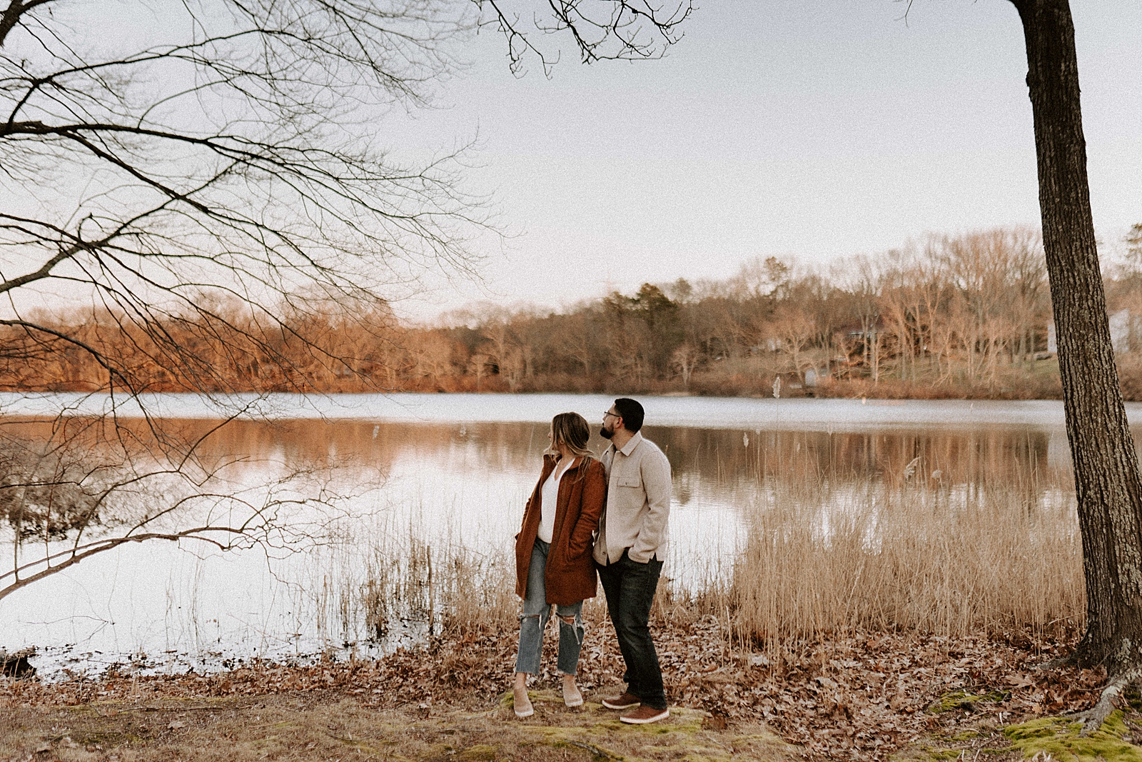 Couple standing by still lake together